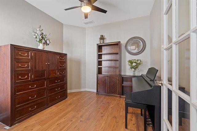 home office featuring light hardwood / wood-style floors and ceiling fan