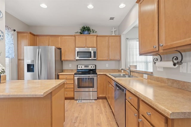 kitchen featuring sink, light wood-type flooring, light brown cabinets, and appliances with stainless steel finishes