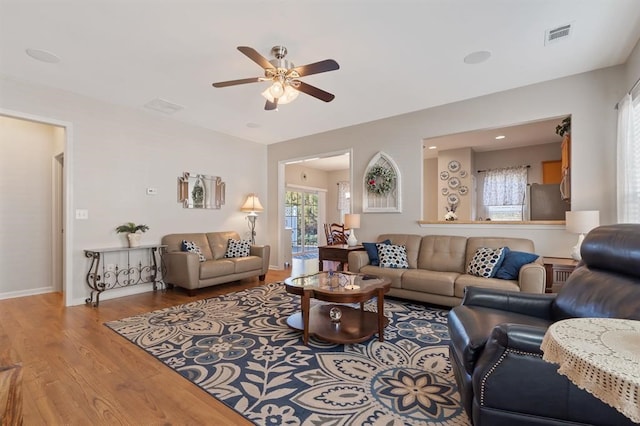 living room featuring wood-type flooring and ceiling fan