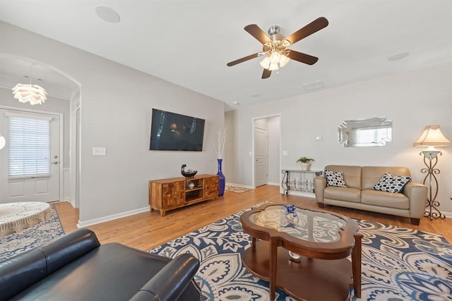 living room featuring a wealth of natural light, ceiling fan, and light wood-type flooring