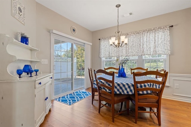 dining space featuring an inviting chandelier and light hardwood / wood-style flooring