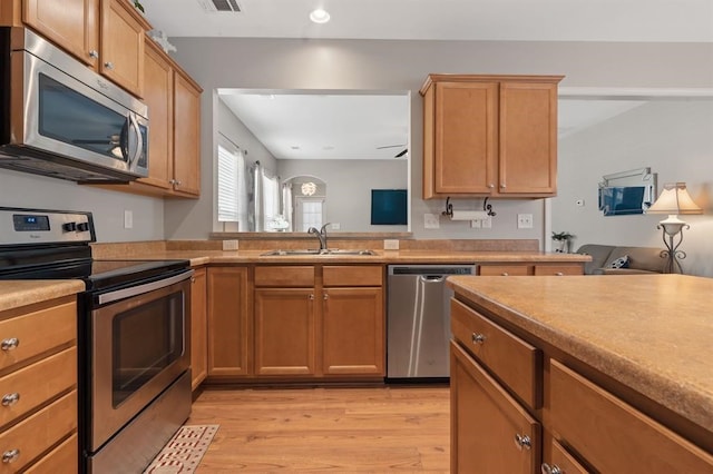 kitchen featuring stainless steel appliances, light hardwood / wood-style floors, and sink