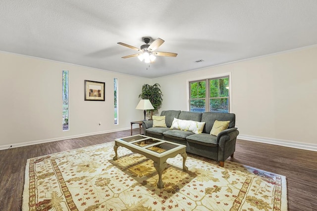 living room with ceiling fan, dark hardwood / wood-style flooring, and ornamental molding