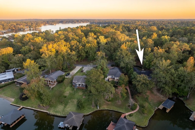 aerial view at dusk featuring a water view