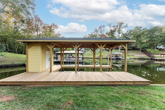 view of dock featuring a water view, boat lift, and a yard