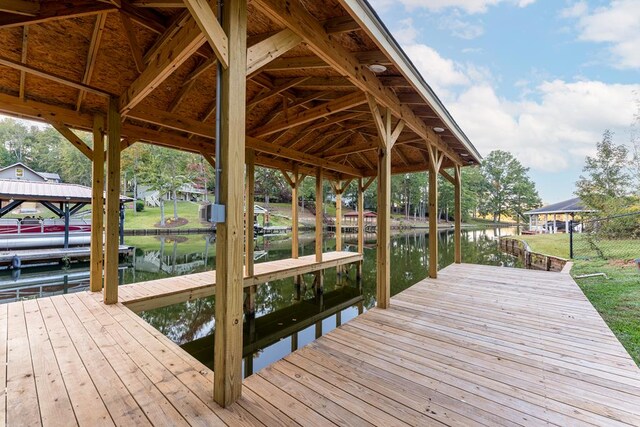 dock area with a lawn and a water view