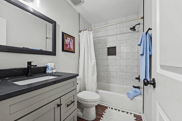 bathroom featuring visible vents, toilet, shower / bath combo, vanity, and wood finished floors