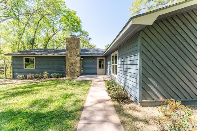 view of front of house featuring a chimney and a front yard