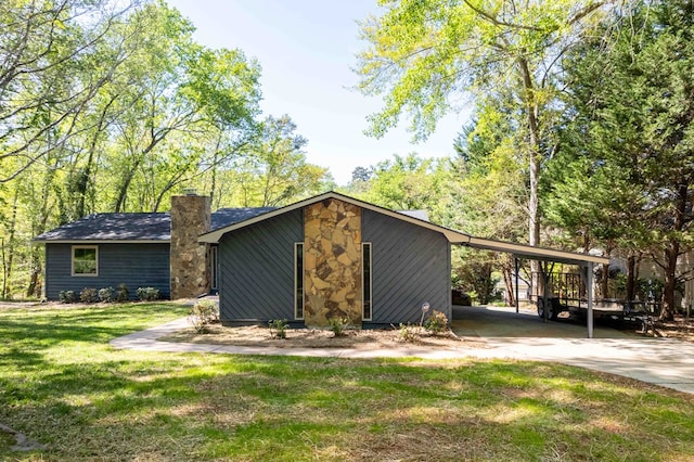 view of outdoor structure with a carport and concrete driveway