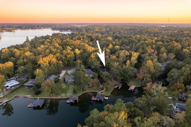 aerial view at dusk featuring a water view