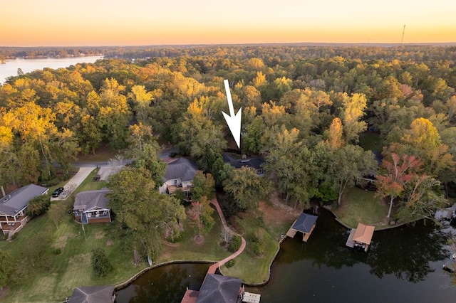 aerial view at dusk featuring a water view