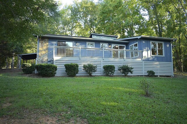 rear view of property featuring a lawn