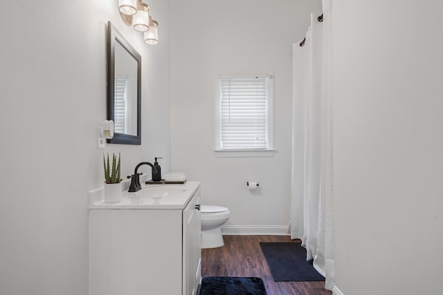 bathroom with hardwood / wood-style floors, vanity, and toilet