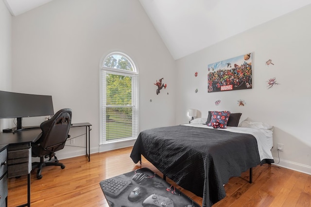 bedroom featuring hardwood / wood-style floors and high vaulted ceiling