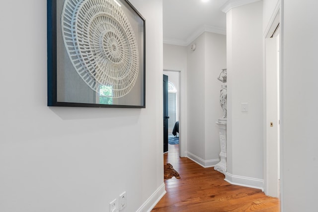 corridor with hardwood / wood-style flooring and crown molding