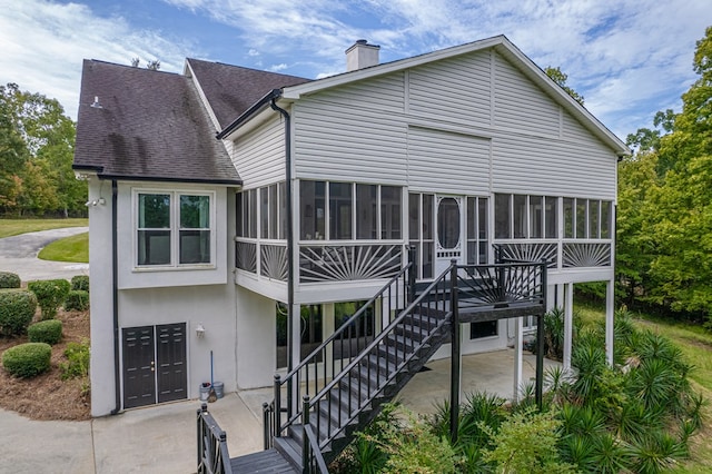 rear view of property with a sunroom and a patio