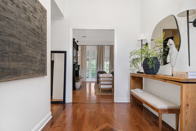 corridor with dark hardwood / wood-style floors and crown molding