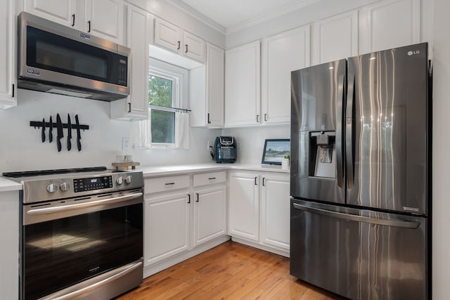 kitchen with white cabinetry, crown molding, light wood-type flooring, and appliances with stainless steel finishes