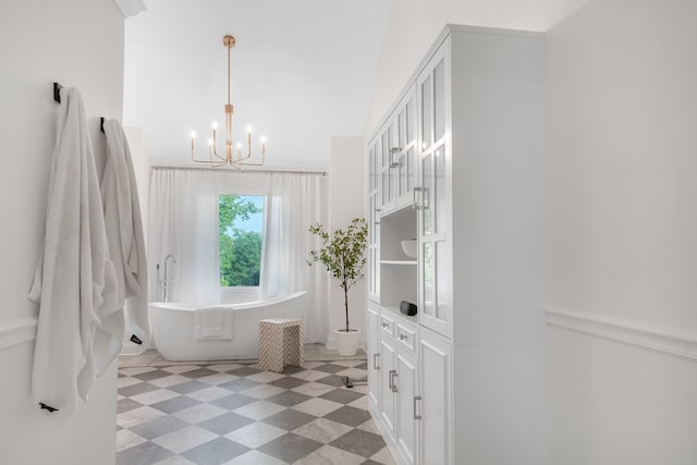 bathroom featuring a notable chandelier, a bathtub, and toilet