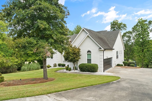 view of front of house featuring a front lawn and a garage