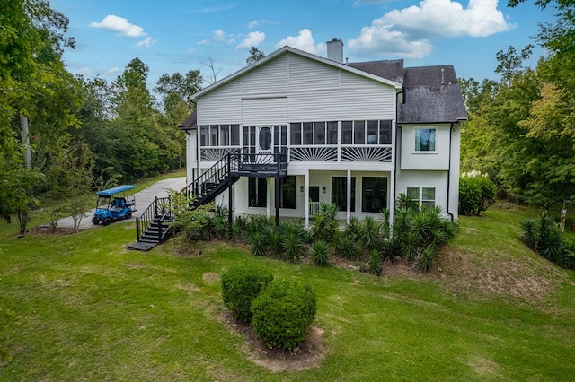 rear view of house featuring a sunroom and a yard