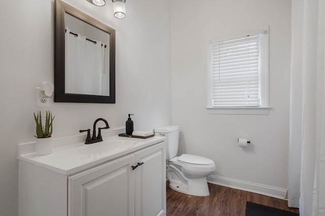 bathroom with wood-type flooring, vanity, and toilet