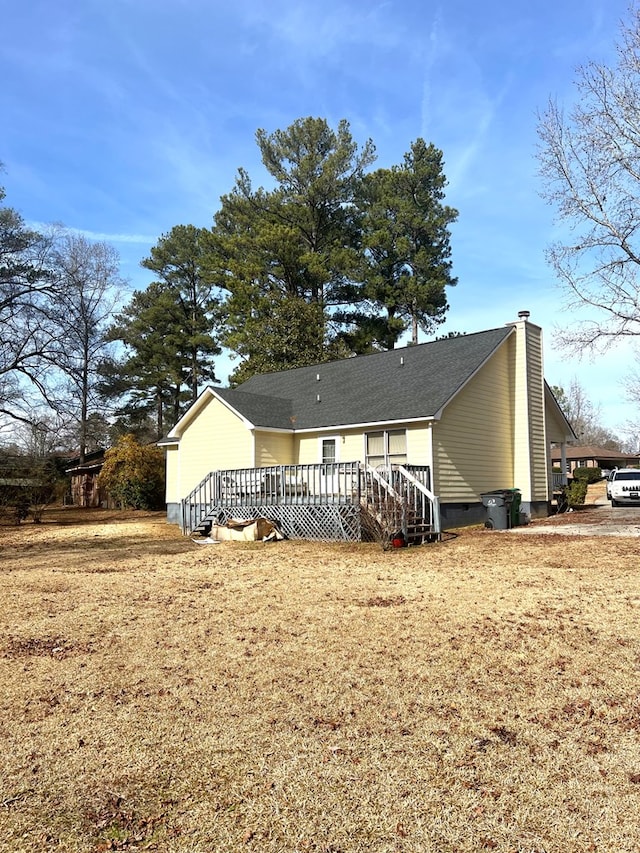 rear view of house featuring stairs, crawl space, a lawn, a wooden deck, and a chimney