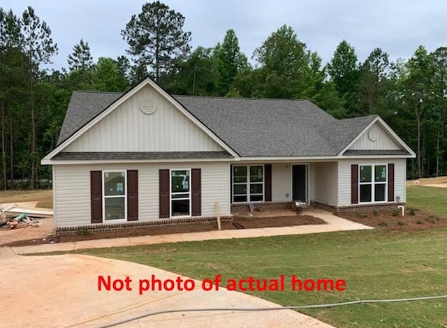 465 Riley Cir, Milledgeville, GA 31061 - view of front facade with a front lawn, a shingled roof, and board and batten siding