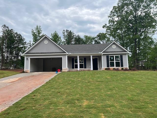 465 Riley Cir, Milledgeville, GA 31061 - view of front of home with an attached garage, concrete driveway, covered porch, and a front yard