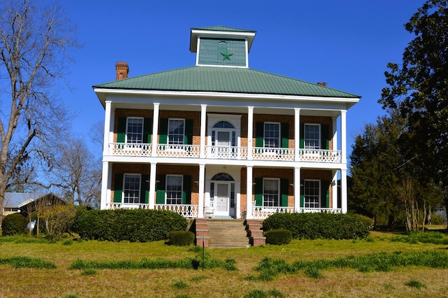 view of front of home with a balcony, a front lawn, and a porch