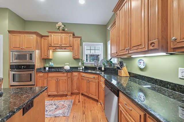 229 Old Plantation Trl, Milledgeville, GA 31061 - kitchen with appliances with stainless steel finishes, a sink, brown cabinetry, dark stone countertops, and light wood-type flooring