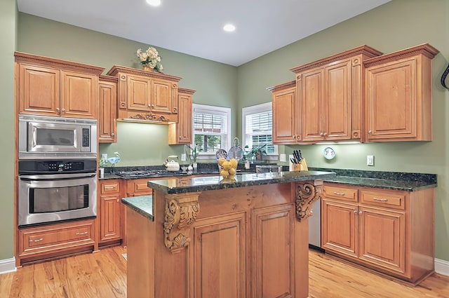 229 Old Plantation Trl, Milledgeville, GA 31061 - kitchen with appliances with stainless steel finishes, dark stone countertops, a kitchen island, and light wood finished floors