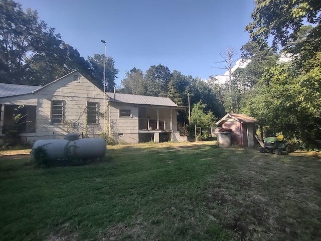 back of house featuring a storage shed and a lawn