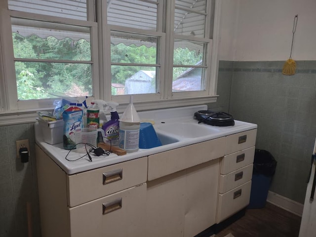 kitchen with white cabinets, a healthy amount of sunlight, and tile walls