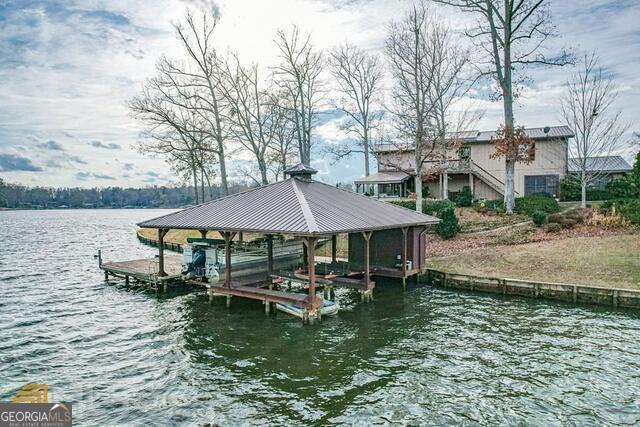 dock area with a water view and boat lift
