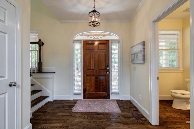 foyer entrance with dark wood-style flooring, healthy amount of natural light, baseboards, and crown molding