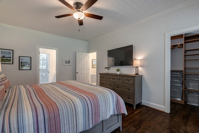 bedroom with dark wood-style flooring, crown molding, baseboards, a spacious closet, and a ceiling fan