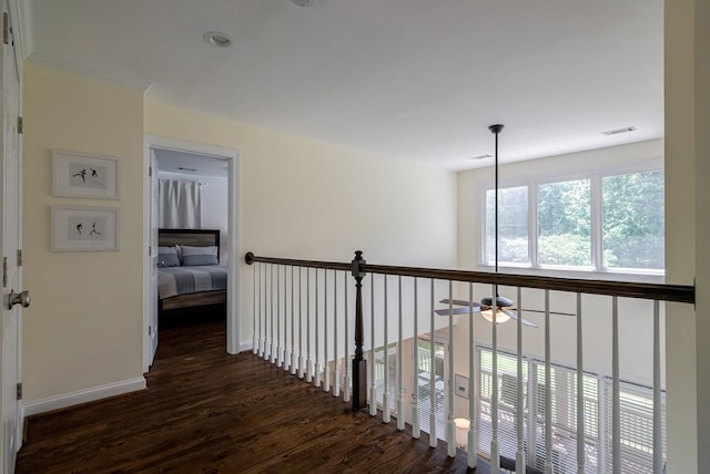 hallway featuring wood finished floors and baseboards