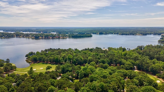 drone / aerial view of a nearby body of water, a golf club, and a forest