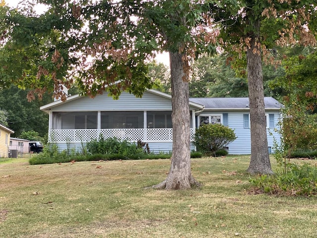 view of front of property featuring a front lawn and a sunroom