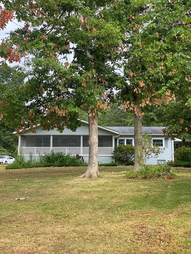 view of front of property with a sunroom and a front yard