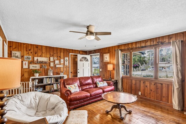 100 Cross Plains Hulett Rd, Carrollton, GA 30016 - living area featuring a textured ceiling, wooden walls, wood finished floors, and a ceiling fan