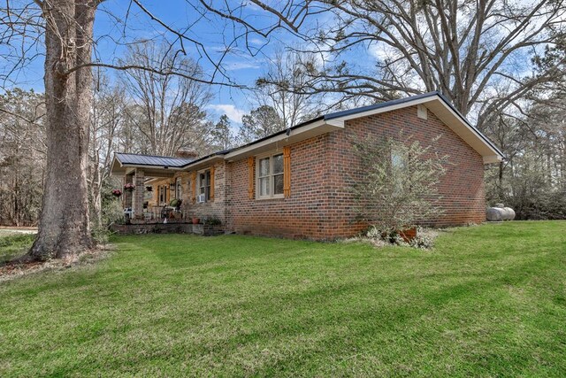100 Cross Plains Hulett Rd, Carrollton, GA 30016 - view of side of home with metal roof, brick siding, and a yard
