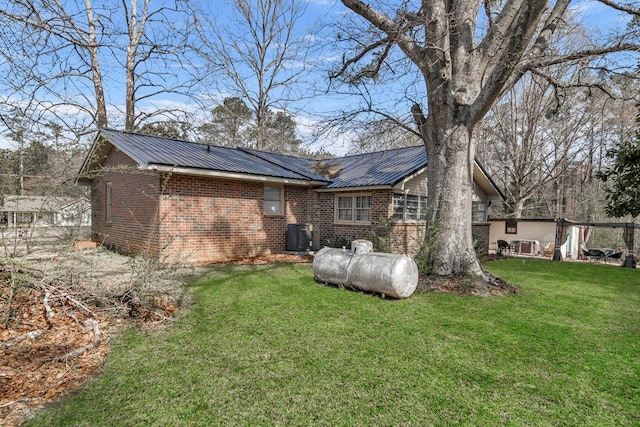 100 Cross Plains Hulett Rd, Carrollton, GA 30016 - back of house with metal roof, central AC unit, brick siding, and a yard