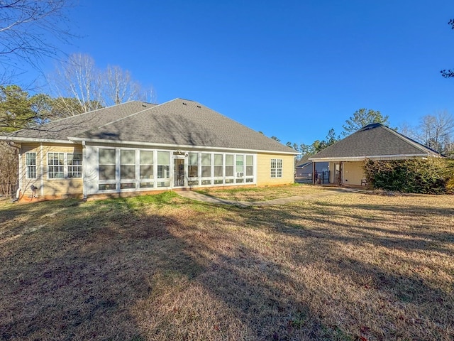 back of property featuring a yard and a sunroom