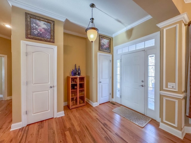 foyer featuring ornamental molding and light wood-type flooring