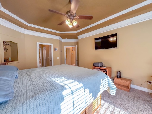 bedroom featuring a raised ceiling, ornamental molding, carpet, and ceiling fan