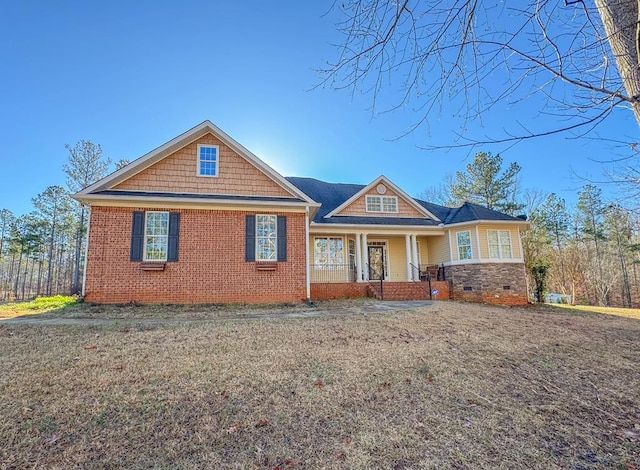 craftsman house featuring covered porch and a front lawn