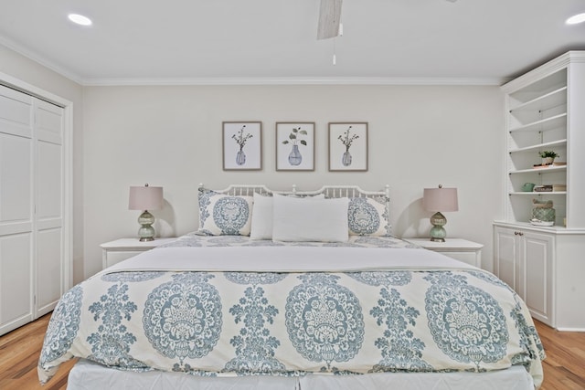 bedroom featuring ceiling fan, a closet, ornamental molding, and light hardwood / wood-style flooring