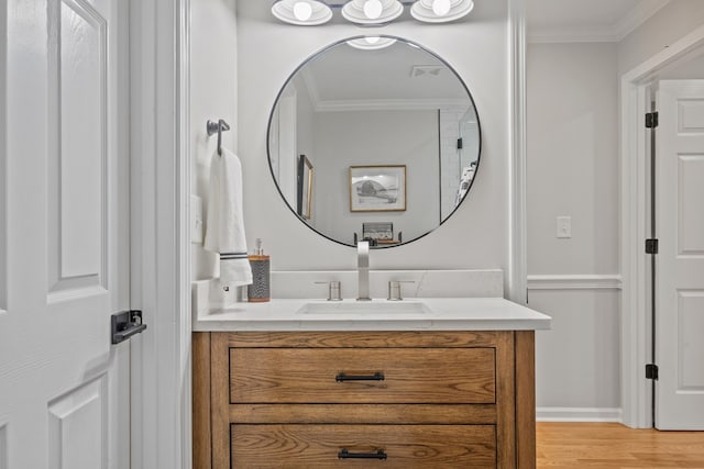 bathroom featuring vanity, ornamental molding, and hardwood / wood-style flooring